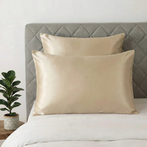 2 taie d'oreiller en soie beige champagne une carré et une rectangle posé sur un lit blanc 