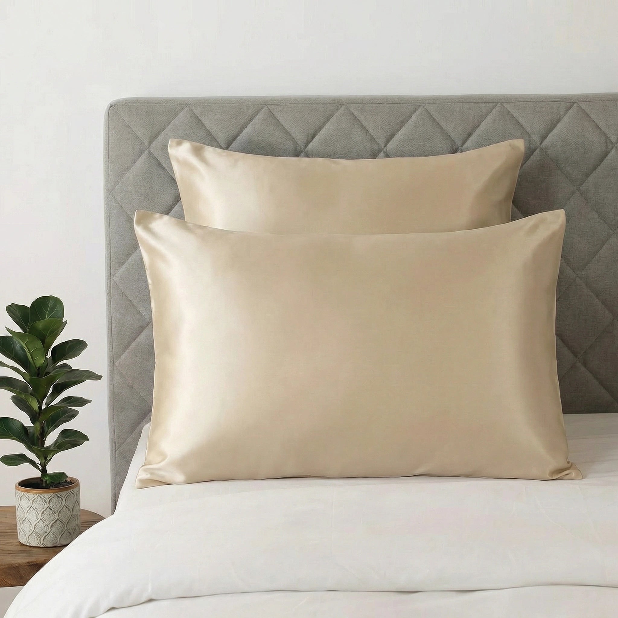 2 taie d'oreiller en soie beige champagne une carré et une rectangle posé sur un lit blanc 